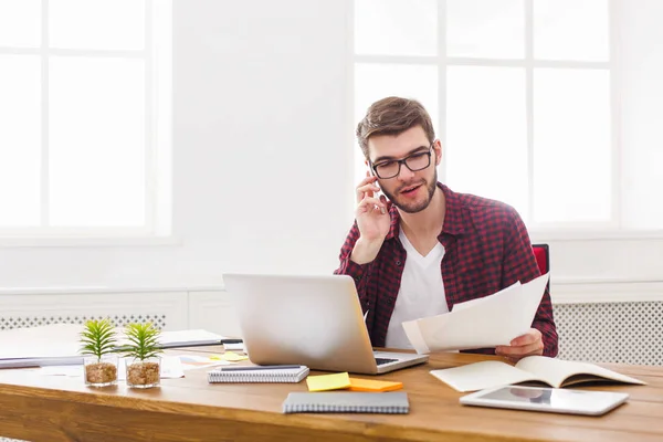 Jeune homme d'affaires concentré lire des documents dans le bureau blanc moderne — Photo