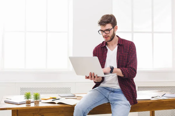 Ung koncentrerad affärsman med laptop i office — Stockfoto
