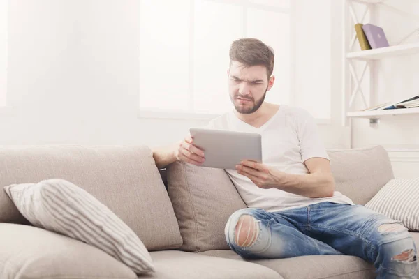 Joven en casa leyendo en la tableta — Foto de Stock