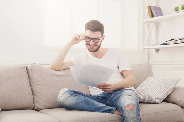 Feliz joven empresario leyendo papeleo en casa — Foto de Stock