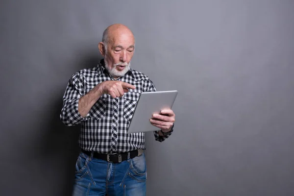 Äldre man läsa nyheter på digitala tablett — Stockfoto