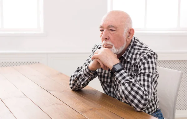 Pensivo homem idoso sentado à mesa, espaço de cópia — Fotografia de Stock