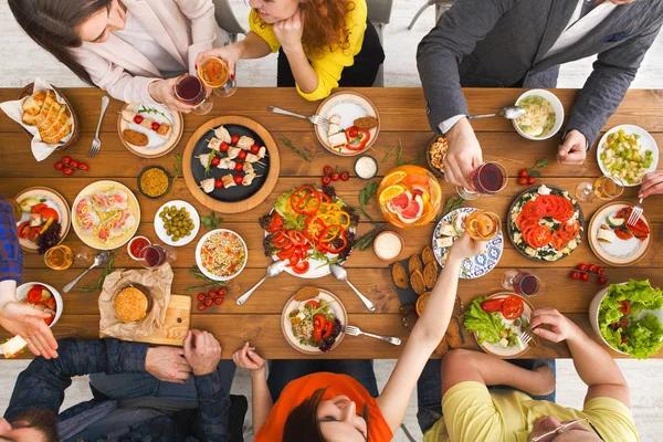 Mensen eten gezonde maaltijden op tafel geserveerd diner — Stockfoto