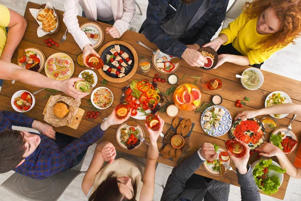 Mensen eten gezonde maaltijden op tafel geserveerd diner — Stockfoto