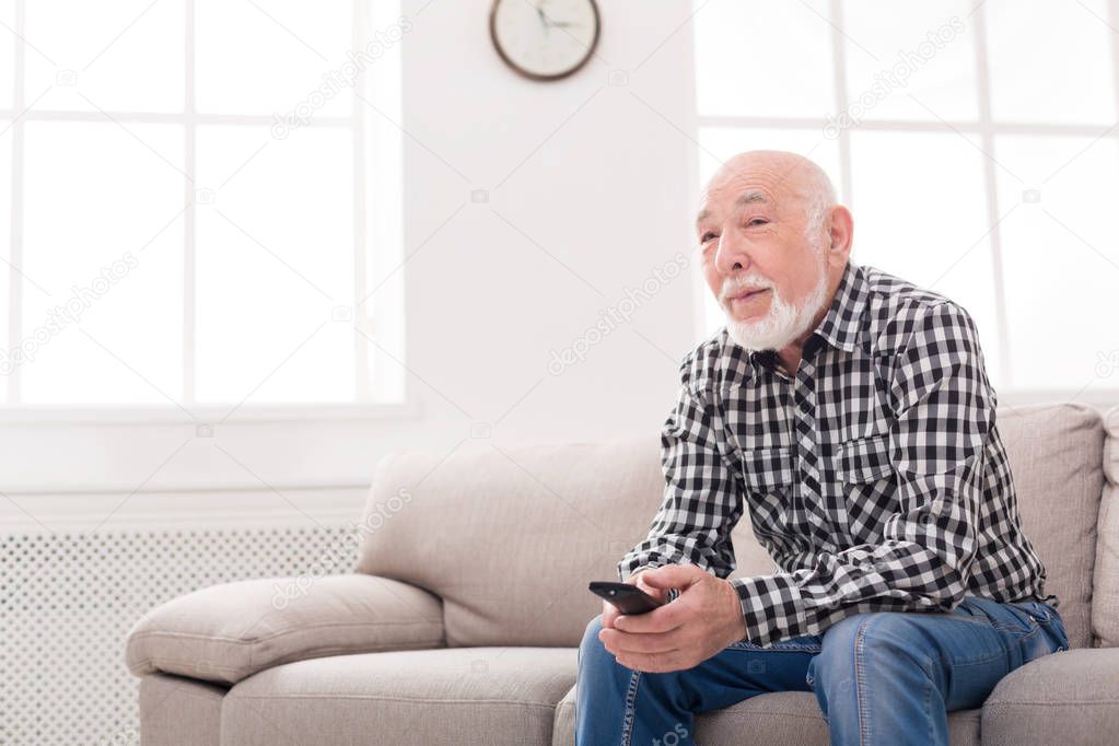 Calm senior man watching tv copy space