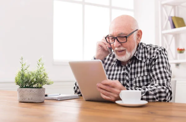 Hombre mayor hablando por teléfono con la tableta — Foto de Stock