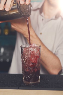 Genç barmen kokteyl içki cam içine dökme