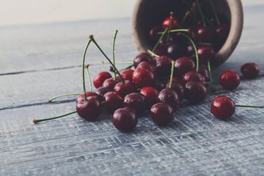 Taze kiraz closeup mavi rustik ahşap üzerine yeşil yaprakları ile
