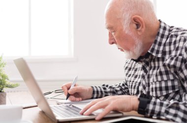 Dizüstü bilgisayar kullanma ve Not Defteri'nde yazma olgun adam