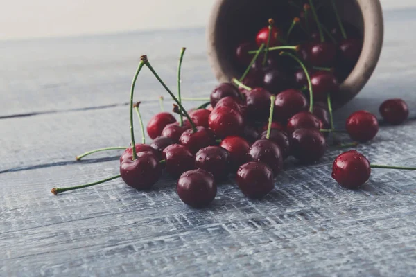Taze kiraz closeup mavi rustik ahşap üzerine yeşil yaprakları ile