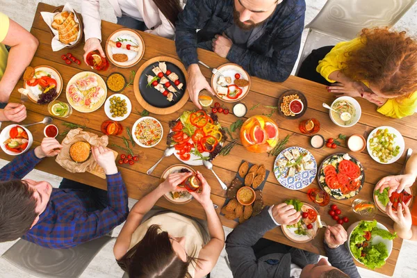 Mensen eten gezonde maaltijden op tafel geserveerd diner — Stockfoto