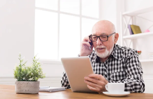 Hombre mayor hablando por teléfono con la tableta — Foto de Stock