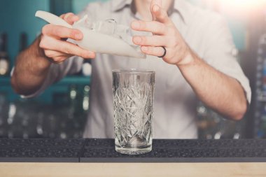 Barmen kokteyl için dökülen buz eller