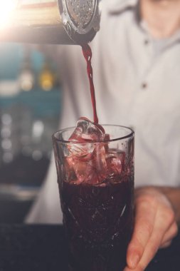 Genç barmen kokteyl içki cam içine dökme