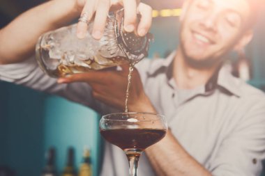 Genç barmen kokteyl içki cam içine dökme
