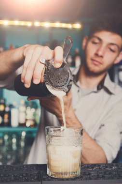 Genç barmen kokteyl içki cam içine dökme