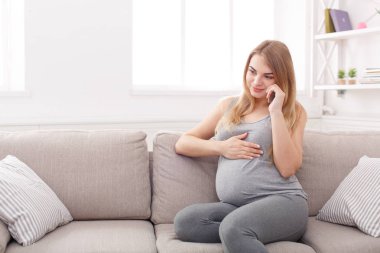 Gülümseyen hamile kadın onun smartphone üzerinde söz