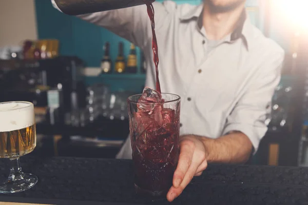 Jonge barman cocktail drinken in glas gieten — Stockfoto