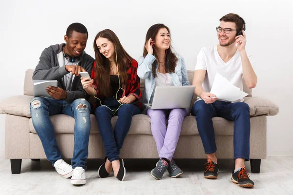 Jóvenes diversos escuchan música con gadgets — Foto de Stock