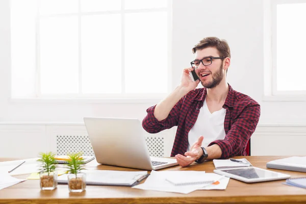 Joven hombre de negocios tiene una charla móvil en la oficina blanca moderna — Foto de Stock