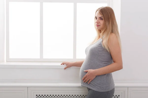 Pegnant žena hladí její břicho doma — Stock fotografie