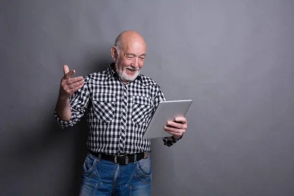 Äldre man läsa nyheter på digitala tablett — Stockfoto