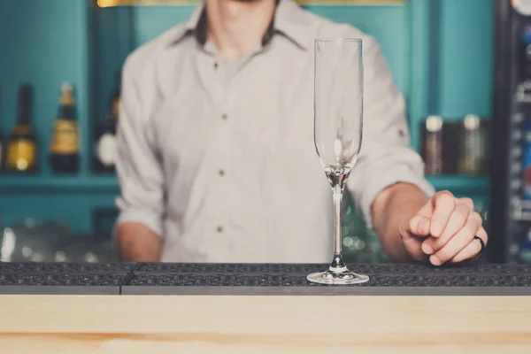 Barman met lege champagne glas in staaf — Stockfoto