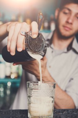 Genç barmen kokteyl içki cam içine dökme