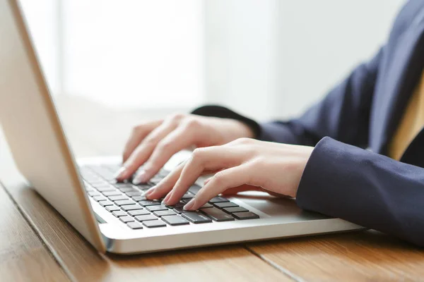 Ділова жінка використовує ноутбук на робочому місці, крупним планом — стокове фото
