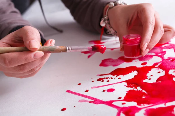 Escova e jarra de pintura em mãos. Artista criando pintura aquarela — Fotografia de Stock