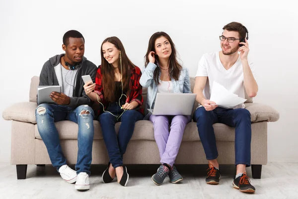 Jóvenes diversos escuchan música con gadgets — Foto de Stock