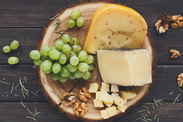 Cheese platter, gouda herb on natural wood disc with grapes and