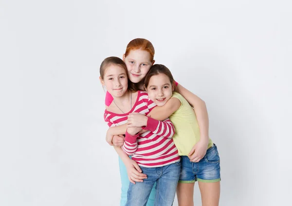 Retrato de três meninas sorridentes no fundo do estúdio branco — Fotografia de Stock