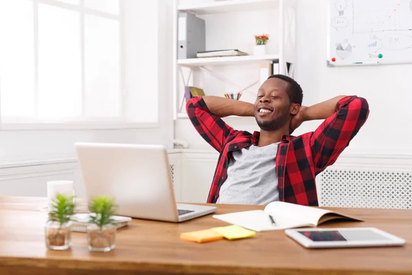 Relajado hombre de negocios negro con portátil en la oficina blanca moderna —  Fotos de Stock