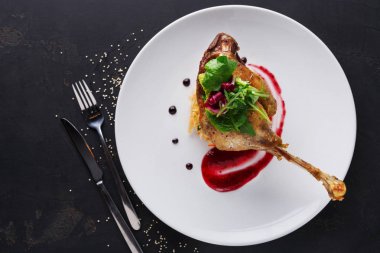 Restoran yemekleri. Ördek confit siyah arka plan üzerine sebzeli