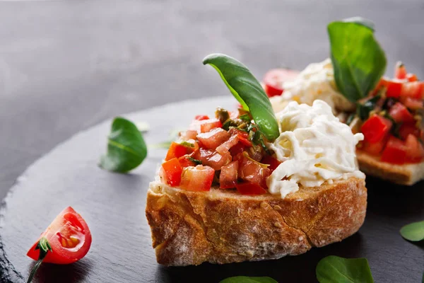 Bruschetta peynir ve siyah arka plan üzerine sebze ile — Stok fotoğraf