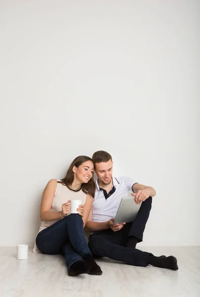 Pareja alegre usando el ordenador portátil en casa, espacio para copiar — Foto de Stock