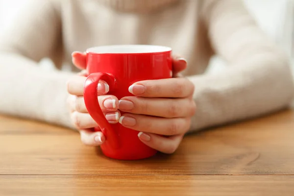 Weibchen mit einer Tasse Heißgetränk, Nahaufnahme — Stockfoto