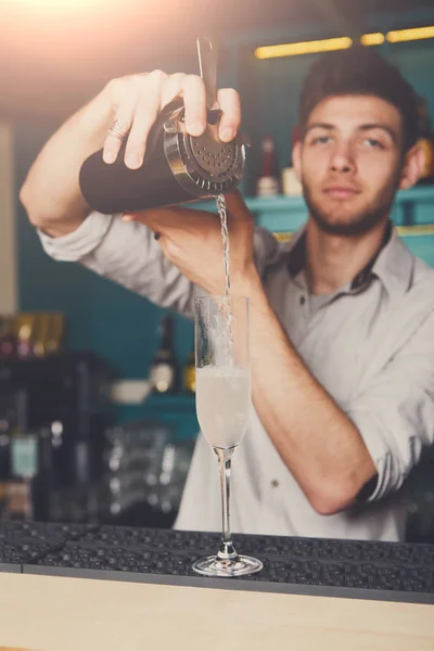 Genç barmen kokteyl içki cam içine dökme — Stok fotoğraf