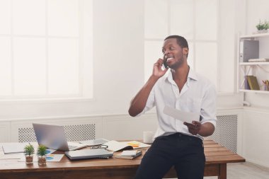 Genç siyah işadamı modern beyaz Office belgeleri okuyun