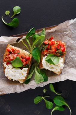 Bruschetta peynir ve siyah arka plan üzerine sebze ile