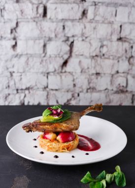 Restoran yemekleri. Ördek confit siyah arka plan üzerine sebzeli