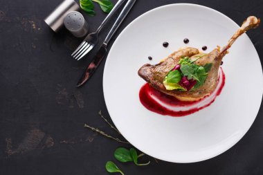 Restoran yemekleri. Ördek confit siyah arka plan üzerine sebzeli