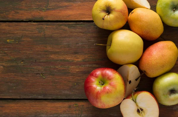 Яблоки и груши на деревянном фоне — стоковое фото