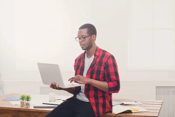 Συλλογισμένος μαύρο επιχειρηματία σε casual γραφείο, εργασία με φορητό υπολογιστή — Φωτογραφία Αρχείου
