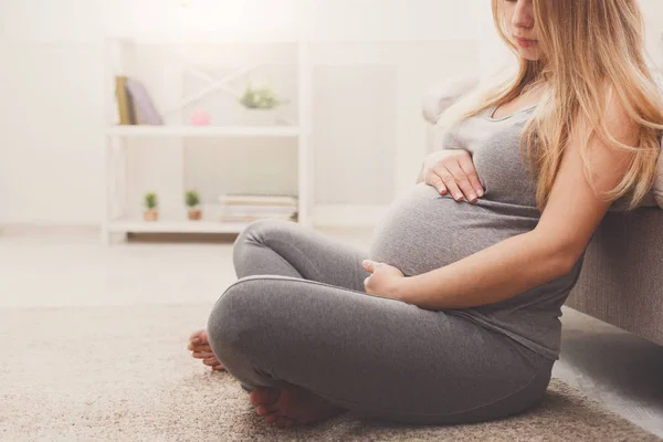 Mujer embarazada irreconocible acariciando su vientre — Foto de Stock