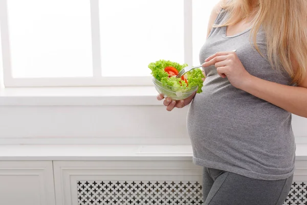 Молода вагітна жінка їсть свіжий зелений салат — стокове фото