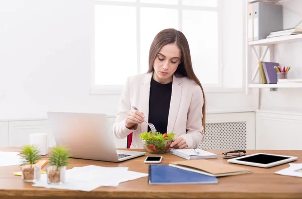 Giovane donna d'affari mangiare insalata in ufficio — Foto Stock