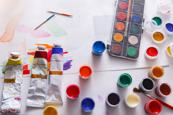 Artist workplace, set of color paints on wood desk