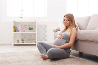 Evde karnı sevecen Pegnant kadın